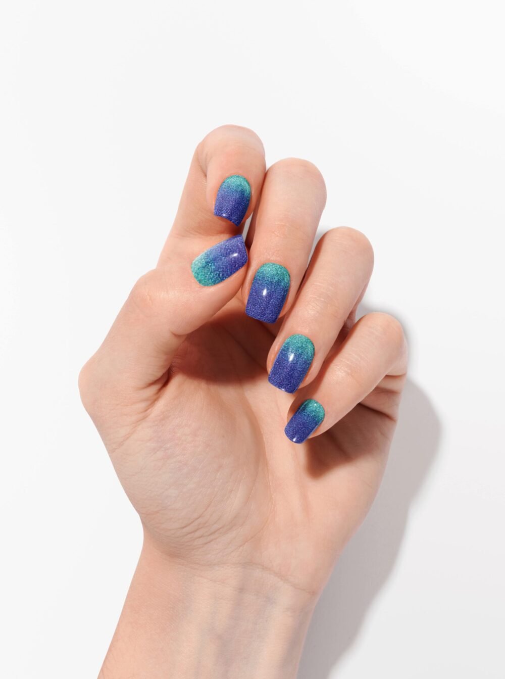 Glitzer für Nägel mit blauem Farbverlauf, auf der Hand getragen