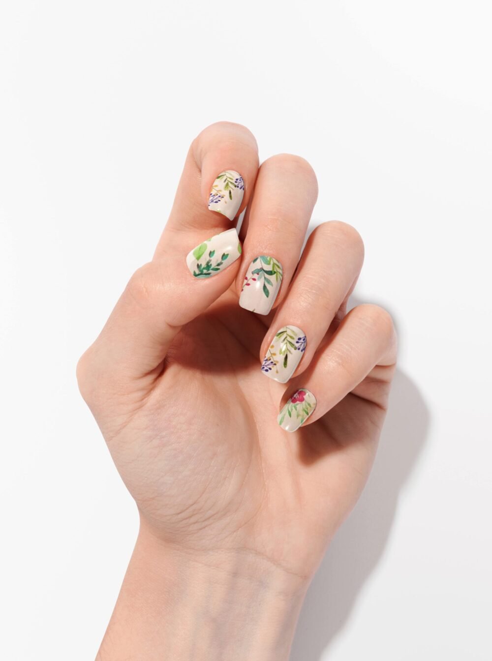 Getragene Nagelfolien mit floralen und blattartigen Motiven auf roséfarbenem Nude-Untergrund